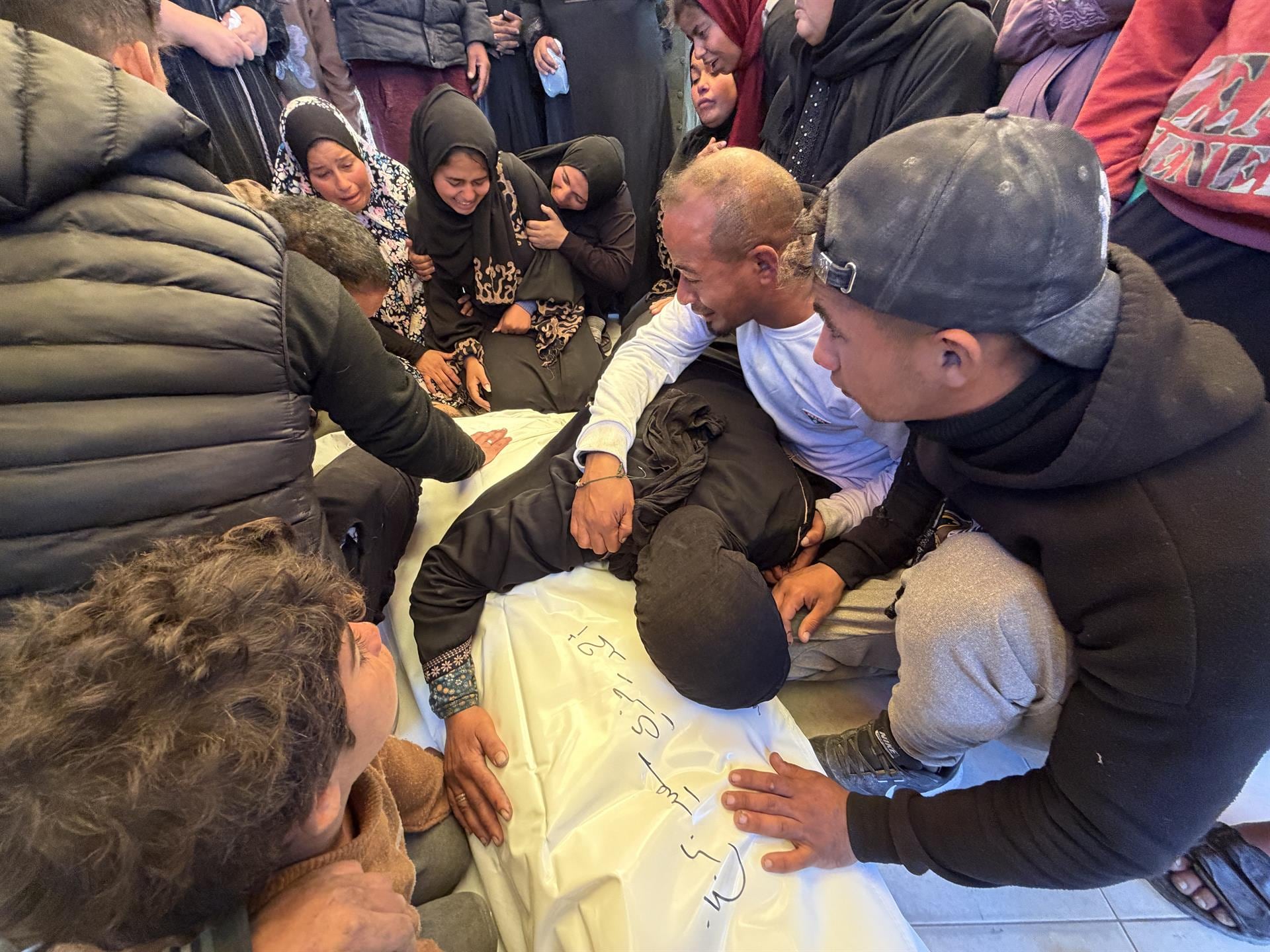 Un grupo de gazatíes junto al cuerpo de una persona (Europa Press)