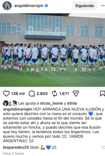 Jugadores de la Selección Argentina de fútbol de espaldas formando un círculo en un campo de entrenamiento verde, con un edificio moderno al fondo