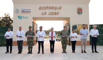 Nueve personas, incluyendo funcionarios y militares, cortan una cinta blanca frente a la entrada del Ecoparque La Ceiba, que tiene logos del Gobierno de México