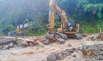 Fotografía cedida por el Ministerio de Obras Públicas que muestra trabajadores mientras operan maquinaria con la que intentan limpiar zonas afectadas por las lluvias en la ciudad de Baños (Ecuador). EFE/Ministerio de Obras Públicas