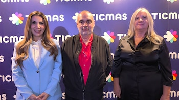 Tres personas sonríen y posan frente a un fondo púrpura con logotipos de Ticmas. Una mujer con blazer claro, un hombre con chaqueta oscura y una mujer con blusa negra