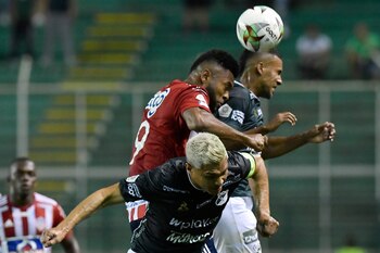 PALMIRA - COLOMBIA, 09-04-2022: Teofilo Gutierrez y Christian Mafla del Cali saltan por el balón con Miguel Borja de Atlético Junior durante partido entre Deportivo Cali y Atlético Junior por la fecha 15 como parte de la Liga BetPlay DIMAYOR I 2022 jugado en el estadio Deportivo Cali de la ciudad de Palmira. / Teofilo Gutierrez and Christian Mafla of Cali jump for the ball with Miguel Borja of Junior during match between Deportivo Cali and Atletico Junior for the date 15 as part of BetPlay DIMAYOR League I 2022 played at Deportivo Cali stadium in Palmira city. Photo: VizzorImage / Gabriel Aponte / Staff