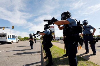 Police officers face protesters after