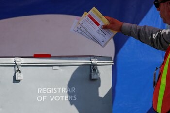 Un trabajador deposita boletas electorales