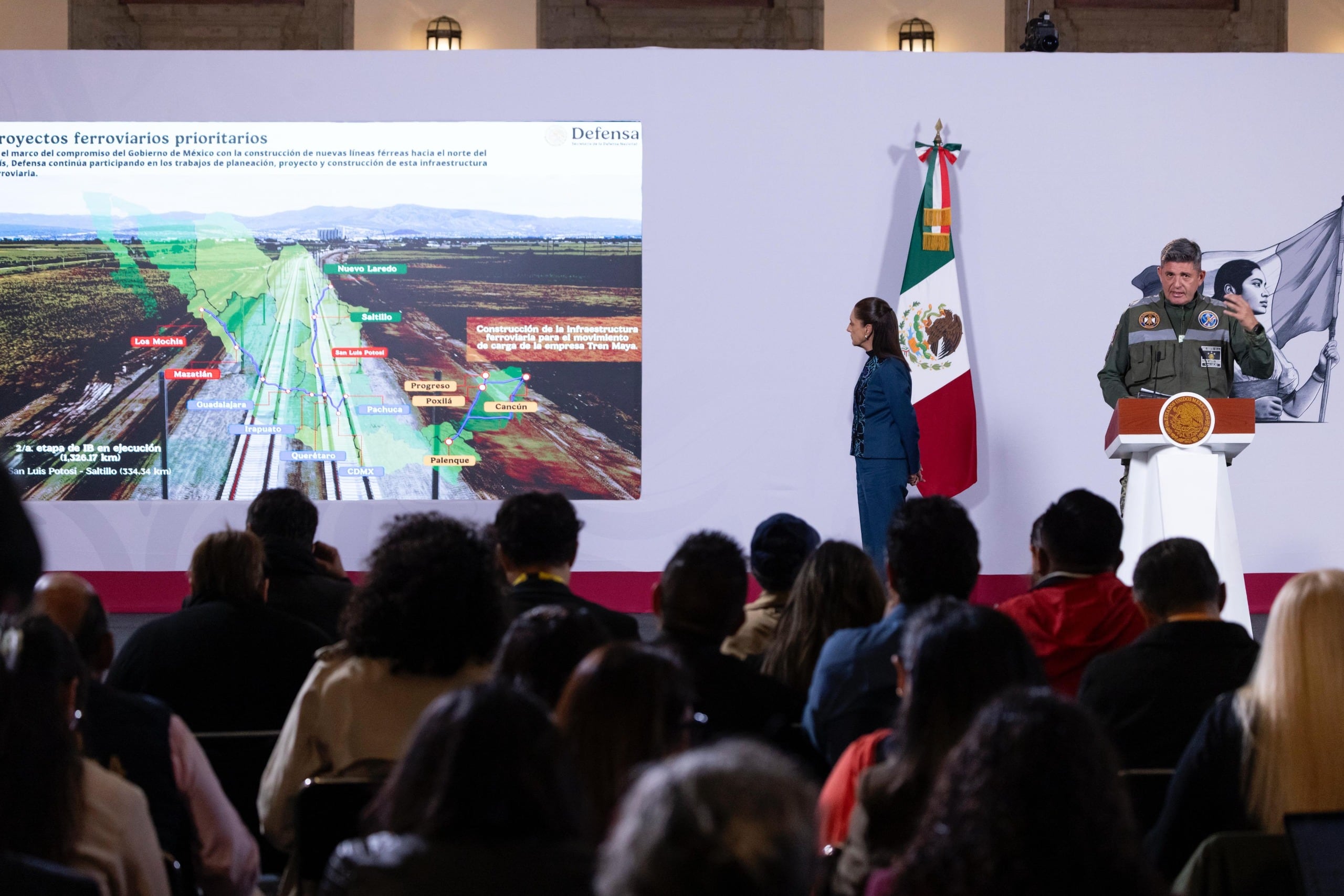 Un mando militar expone los proyectos ferroviarios prioritarios junto a la presidenta Claudia Sheinbaum durante una conferencia gubernamental en México.