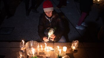 Una mujer prende una vela