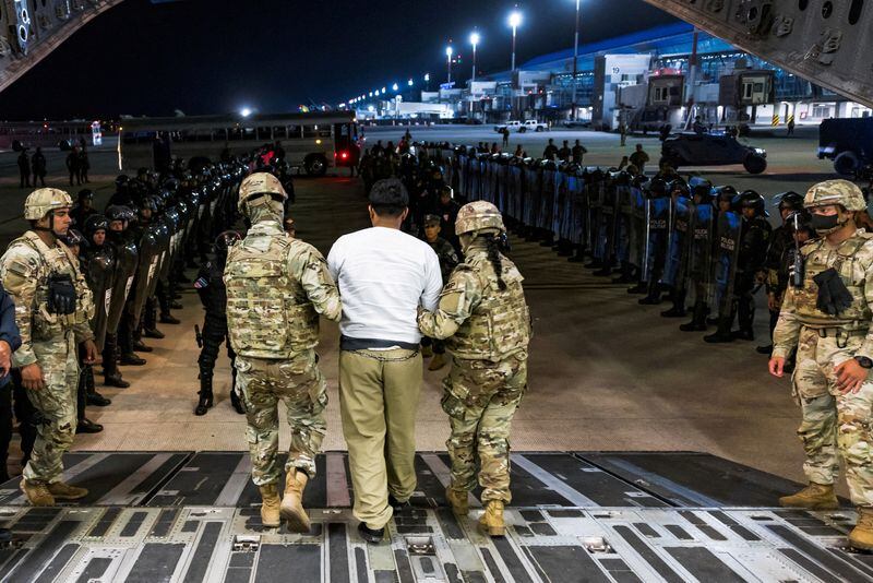 FOTO DE ARCHIVO: Militares estadounidenses escoltan a un presunto pandillero que fue deportado por Estados Unidos junto con otros que Estados Unidos alega son miembros de la pandilla venezolana Tren de Aragua y la pandilla MS-13 para ser encarcelados en la prisión del Centro de Reclusión del Terrorismo (CECOT), en el Aeropuerto Internacional de El Salvador en San Luis Talpa, El Salvador 12 de abril de 2025. (Secretaria de Prensa de la Presidencia/Handout via REUTERS/File Photo)