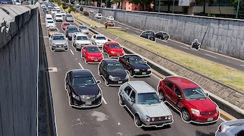 Vista elevada de varios automóviles en una avenida rodeada por muros de concreto, con bordes blancos y textura de cómic.