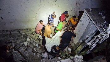 Colaboradores retiran el cuerpo de una de las personas que murieron en el bombardeo contra la escuela (REUTERS/Reuters TV)