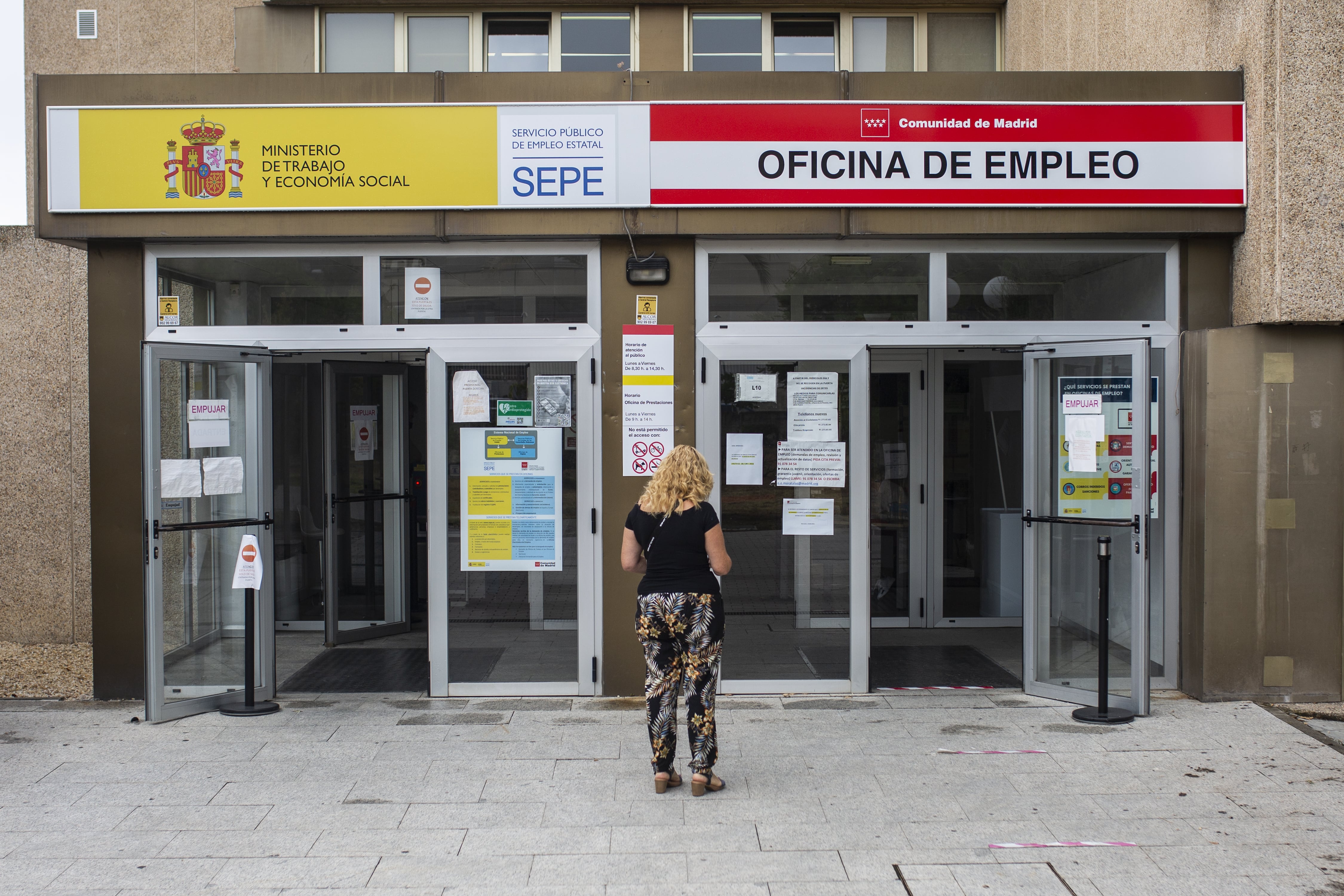 Una mujer a las puertas de una oficina del SEPE y oficina de empleo de la Comunidad de Madrid (Alejandro Martínez Vélez / Europa Press)