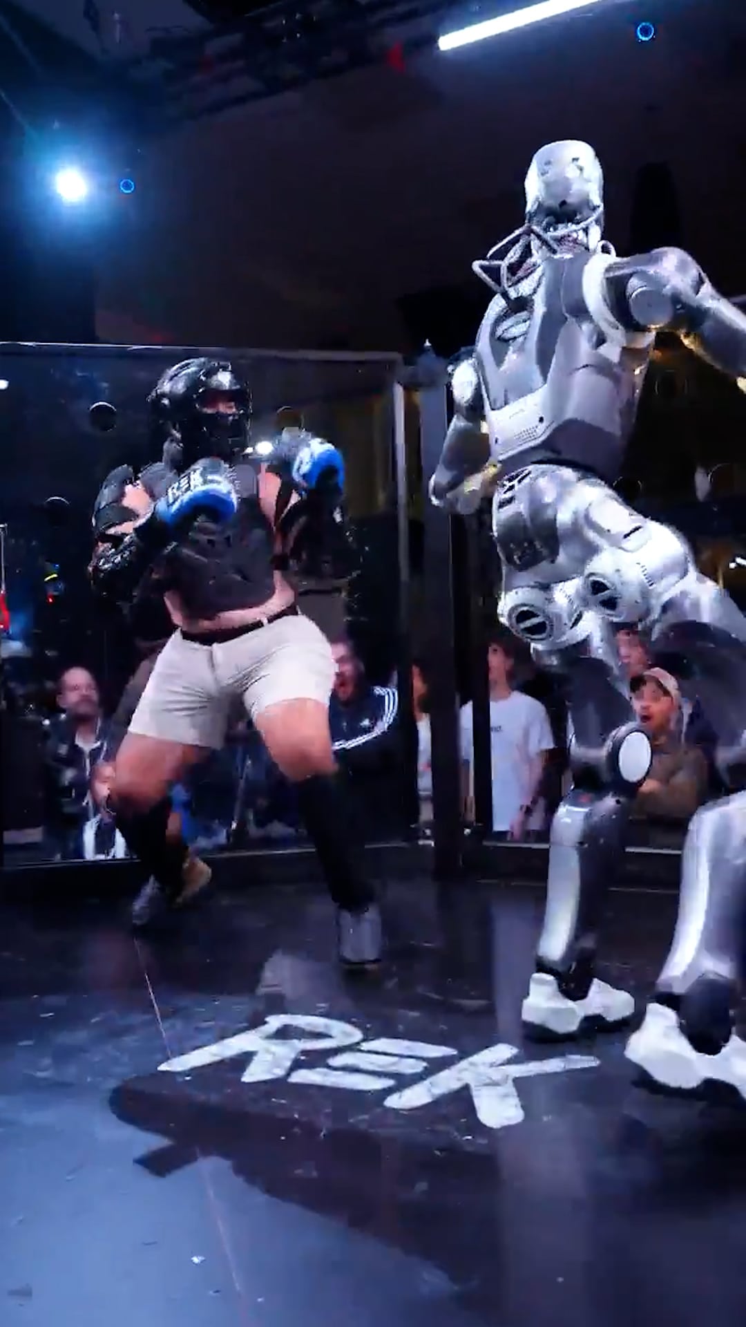 El creador de contenido Frankie LaPenna se enfrenta al robot humanoide REK durante un combate de exhibición en una jaula de artes marciales.