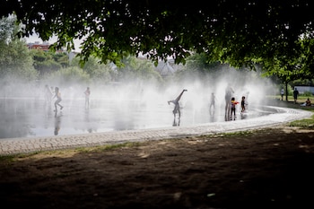 Grupos de niños juegan en una fuente en Madrid, a 18 de junio de 2026. (EFE/ Marcos Villaoslada)