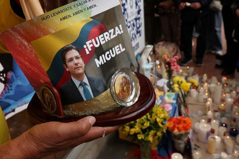 FOTO DE ARCHIVO. Un hombre sostiene una imagen de la Virgen María con una foto del senador colombiano Miguel Uribe Turbay, del partido opositor Centro Democrático, frente a la clínica Fundación Santa Fe, después de que el político sufrió un ataque a bala durante un acto de campaña, en Bogotá, Colombia, 10 de juni, 2025. REUTERS/Luisa Gonzalez