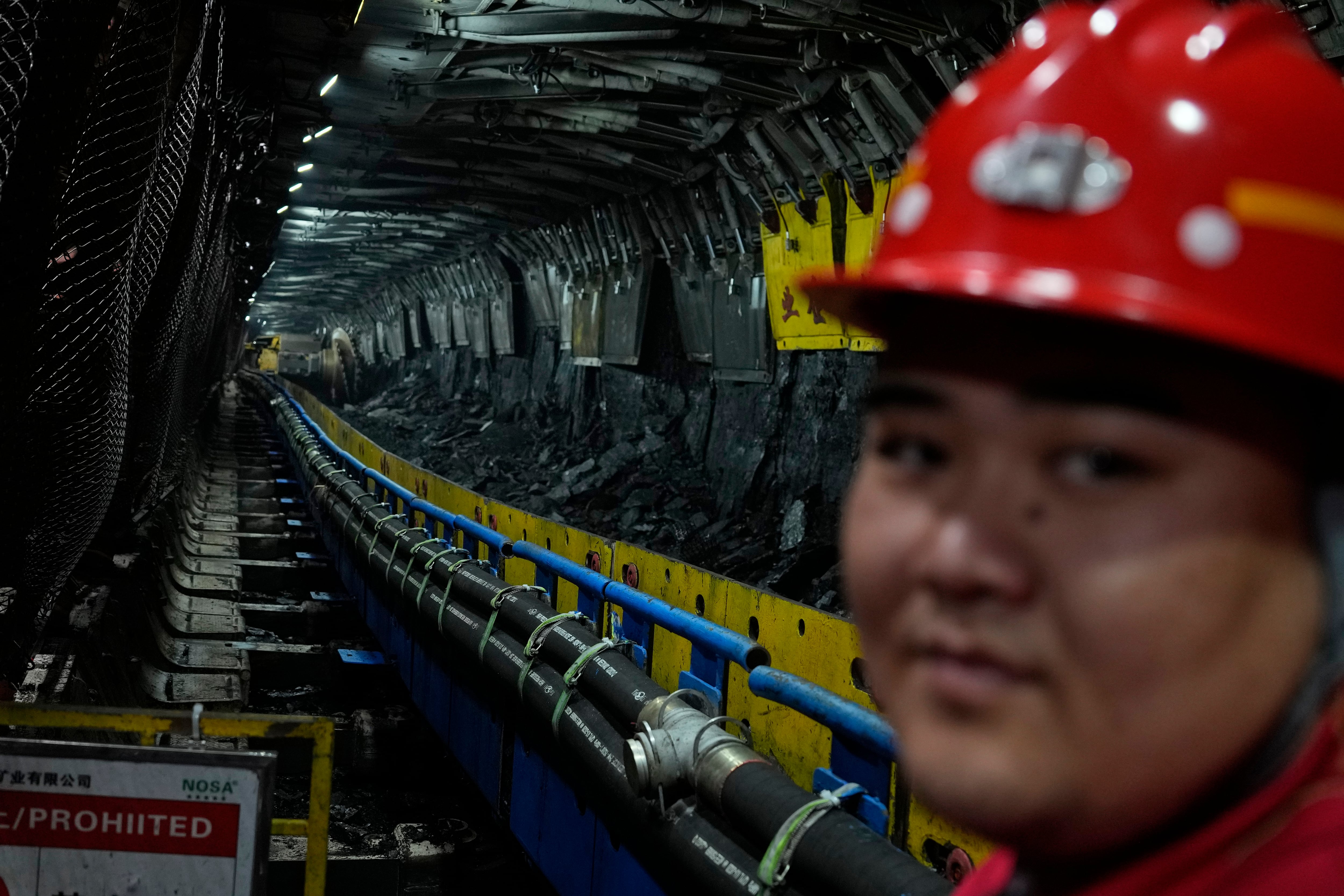 Un trabajador mira a cámara en la mina de carbón de Xiaobaodang, cerca de la ciudad de Shenmu, en la provincia de Shanxi (AP Foto/Ng Han Guan/Archivo)