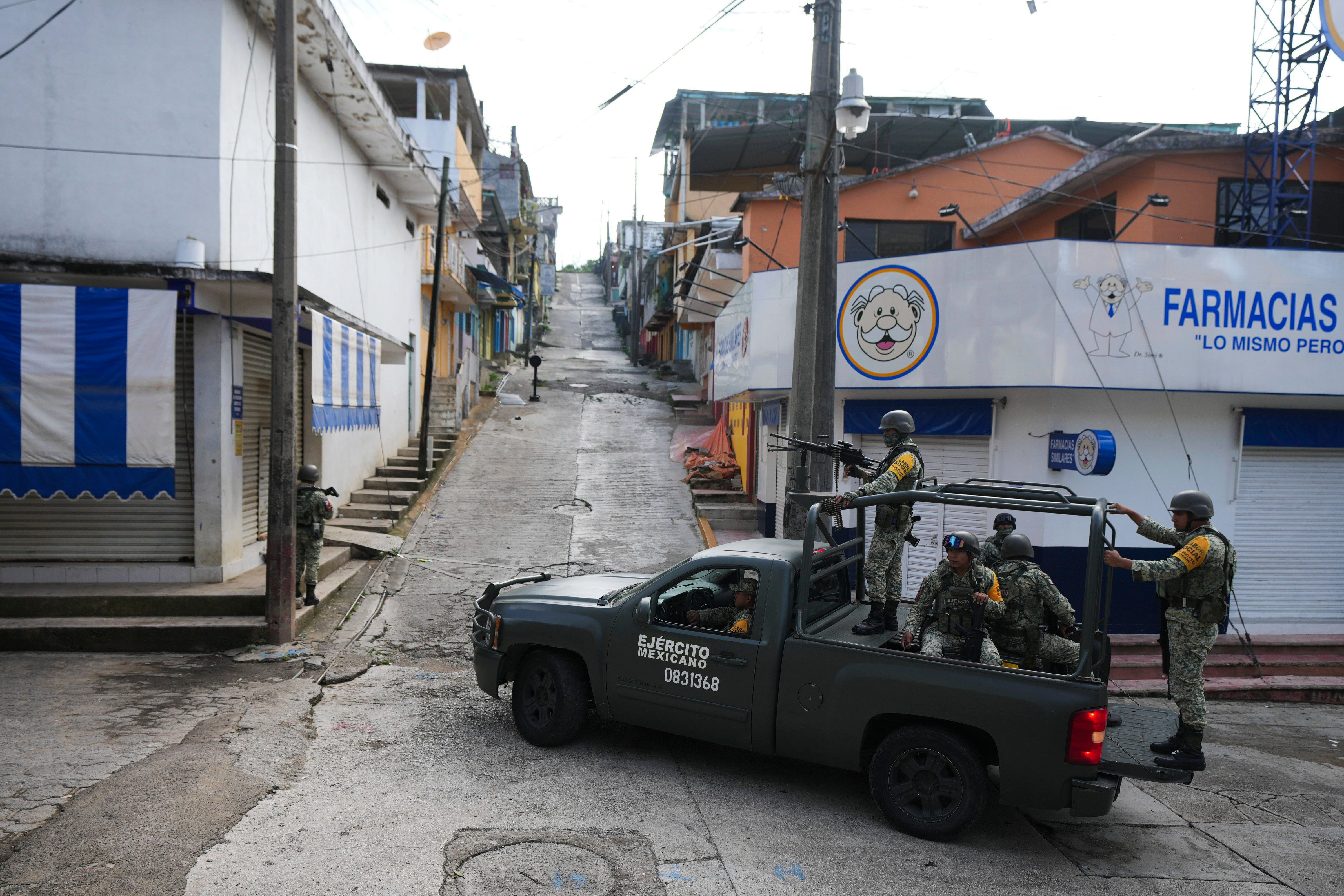 Soldados patrullan junto a comercios cerrados en Tila, en el estado de Chiapas, México, el martes 18 de junio de 2024. La población huye de la localidad debido a la violencia relacionada con el crimen organizado. (AP Foto/Fernando Llano)