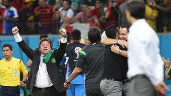 Mexico's coach Miguel Herrera (2nd L) celebrates after his team won a Group A football match between Croatia and Mexico at the Pernambuco Arena in Recife during the 2014 FIFA World Cup on June 23, 2014. Mexico won 3-1. AFP PHOTO / DIMITAR DILKOFF