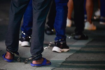 Migrantes colombianos engrilletados hacen fila