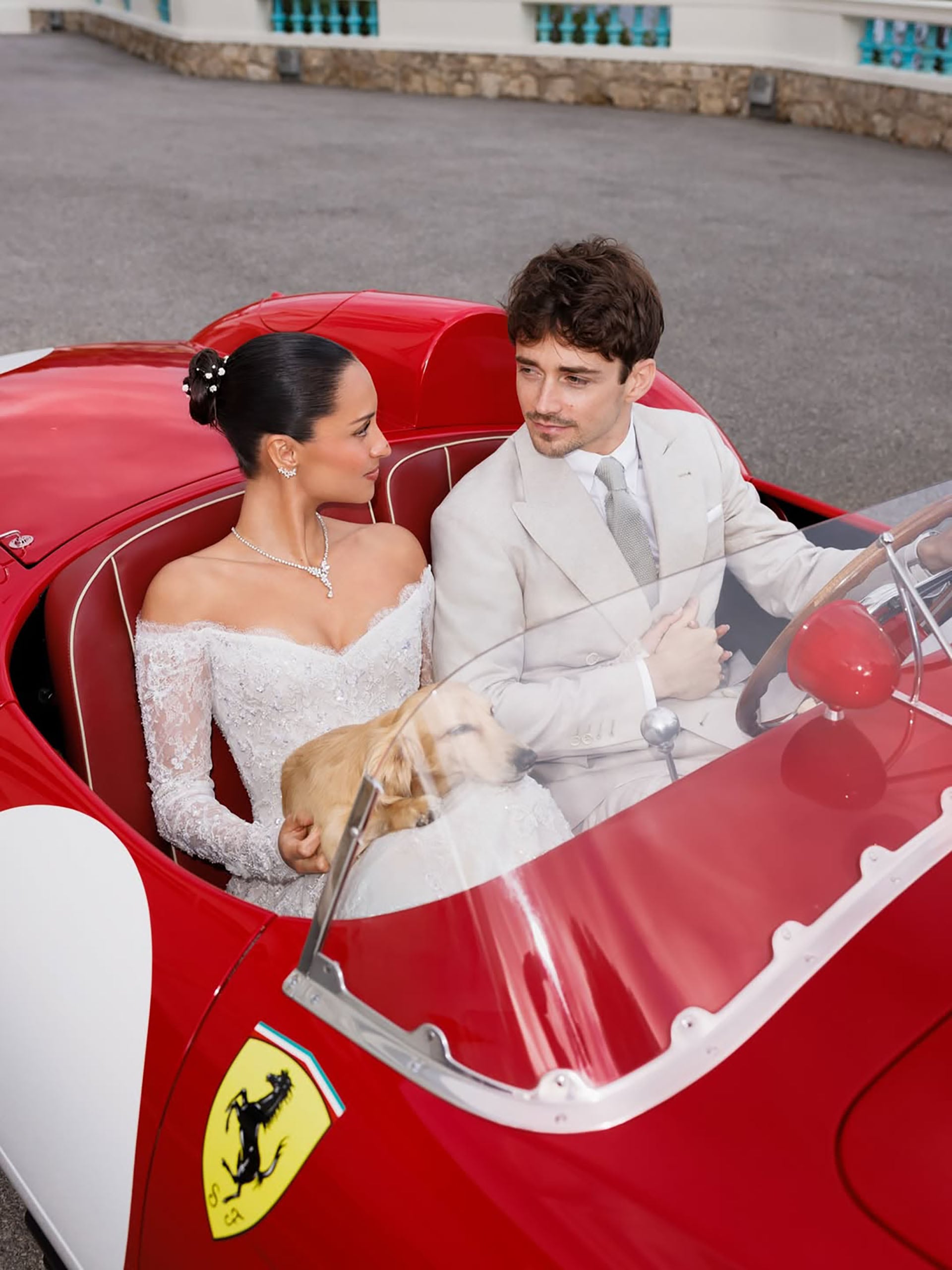 Charles Leclerc y Alexandra Saint Mleux se muestran juntos tras la ceremonia en un coche clásico Ferrari rojo, con su perro Leo