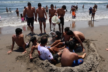 Bathers play with water as