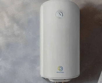 Termo eléctrico blanco cilíndrico de marca Primaterm con reloj indicador de temperatura en la parte superior, colgado en una pared gris