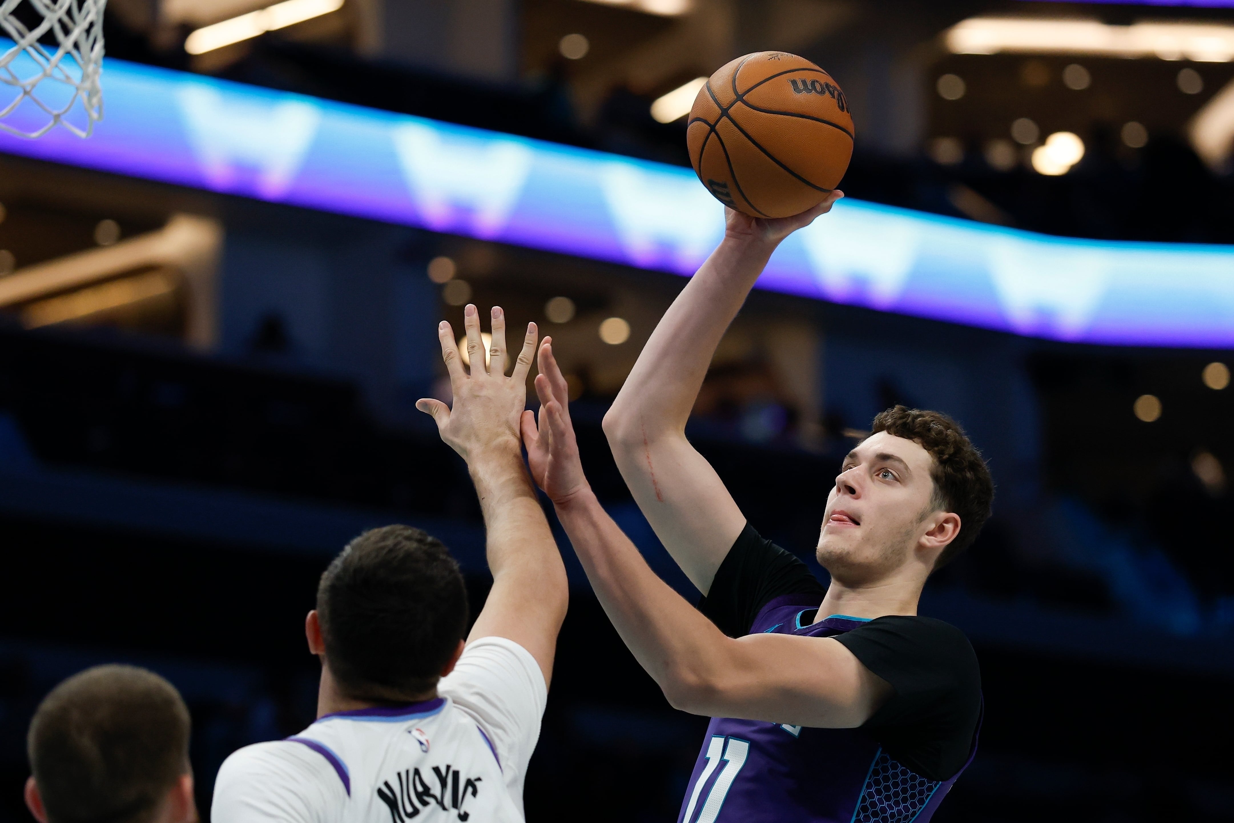 El pívot de los Hornets de Charlotte Ryan Kalkbrenner lanza el balón sobre el pívot del Jazz de Utah Jusuf Nurkic en el encuentro del domingo 2 de noviembre del 2025. (AP Foto/Nell Redmond)