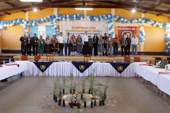Bernardo Arévalo posa junto a personas con indumentaria indígena ante una pancarta de bienvenida en Guatemala