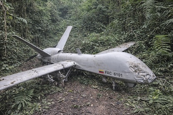 Primer plano de un dron gris accidentado en un denso entorno selvático, con la bandera de Colombia y la matrícula FAC 6101 visibles en su fuselaje.