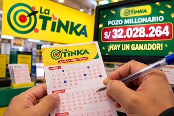 Unas manos marcan un boleto de lotería con un bolígrafo azul frente a una pantalla con el logotipo de La Tinka y cifras en soles