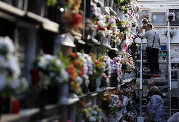 Varias personas colocan flores en