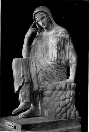 Estatua de mármol en blanco y negro de una mujer sentada con vestimenta drapeada, velo y una mano en el rostro. Base con un letrero que indica "PENELOPE?"