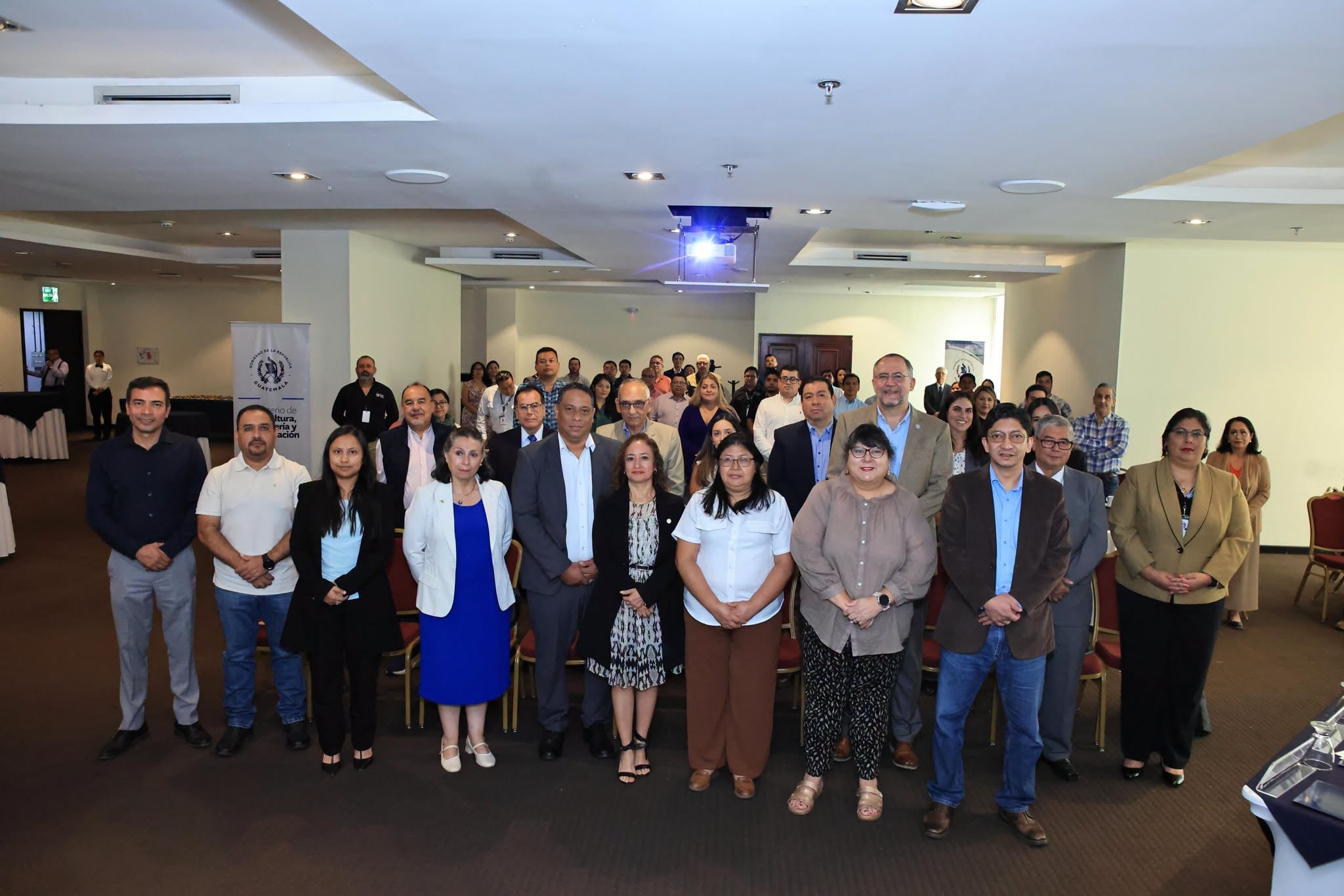 Un grupo de autoridades y funcionarios del Ministerio de Agricultura de Guatemala posa tras una reunión de trabajo en un salón de eventos. (Ministerio de Agricultura, Ganadería y Alimentación)