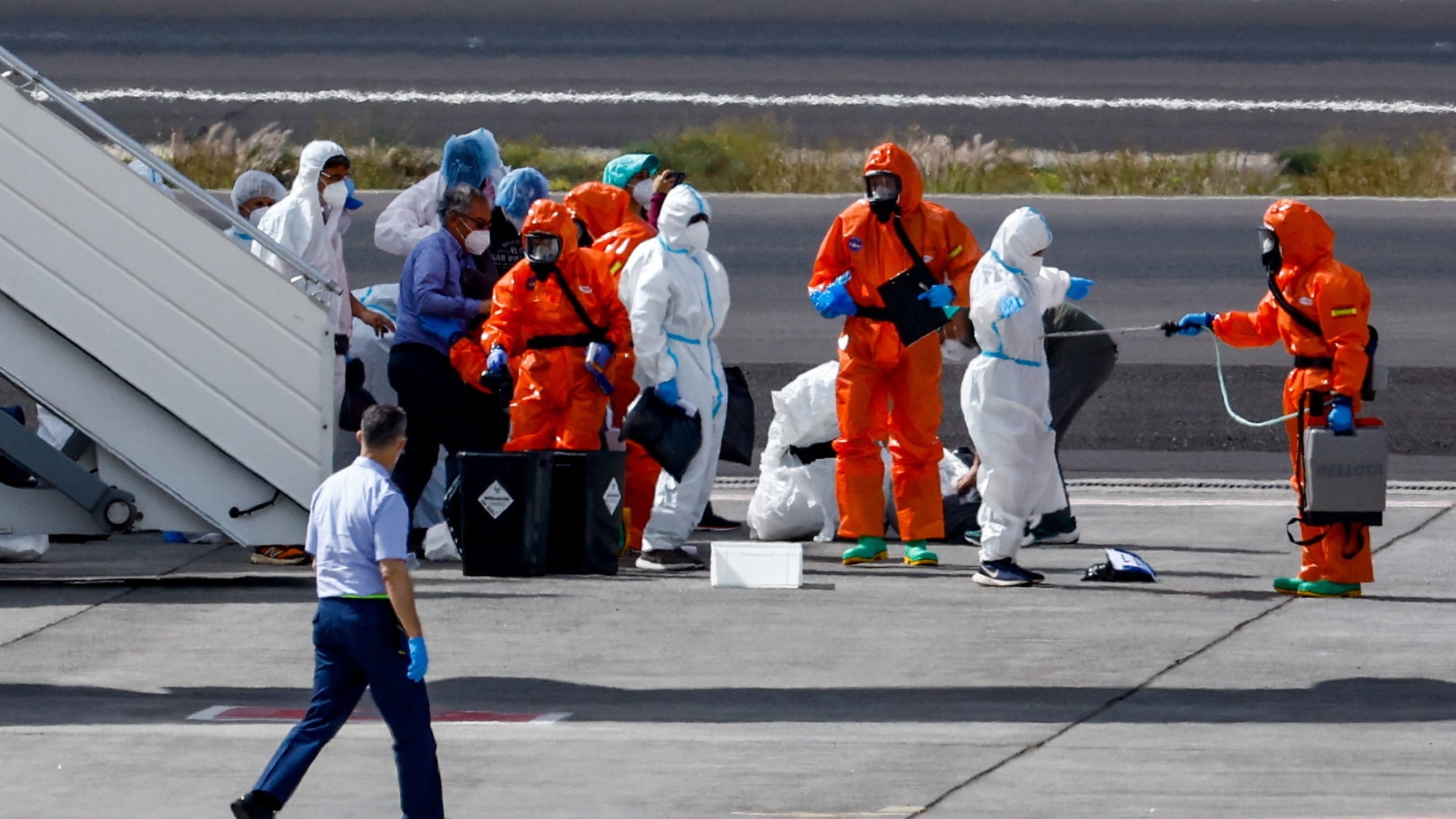 Personas equipadas con material de protección personal realizan los preparativos en la pista del aeropuerto de Tenerife Sur, tras la llegada del crucero MV Hondius, afectado por un brote de hantavirus, Islas Canarias, España, 10 de mayo de 2026. REUTERS/Borja Suárez