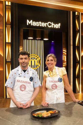 Nazareno Casero y Luciana Geuna con delantales blancos detrás de un mesón con un plato servido, frente al logotipo de MasterChef