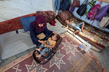 La madre del niño palestino Abdul Rahman Abu Al-Jidyan, que es la primera persona que contrae la polio en Gaza en 25 años, le cuida en su tienda de campaña, en Deir Al-Balah (REUTERS/Ramadan Abed/Fotografía de archivo)