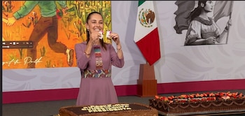 Mujer de púrpura sonríe, sostiene objetos. Fondo con pantalla, bandera de México e ilustración. Dos pasteles de chocolate con fresas y arándanos