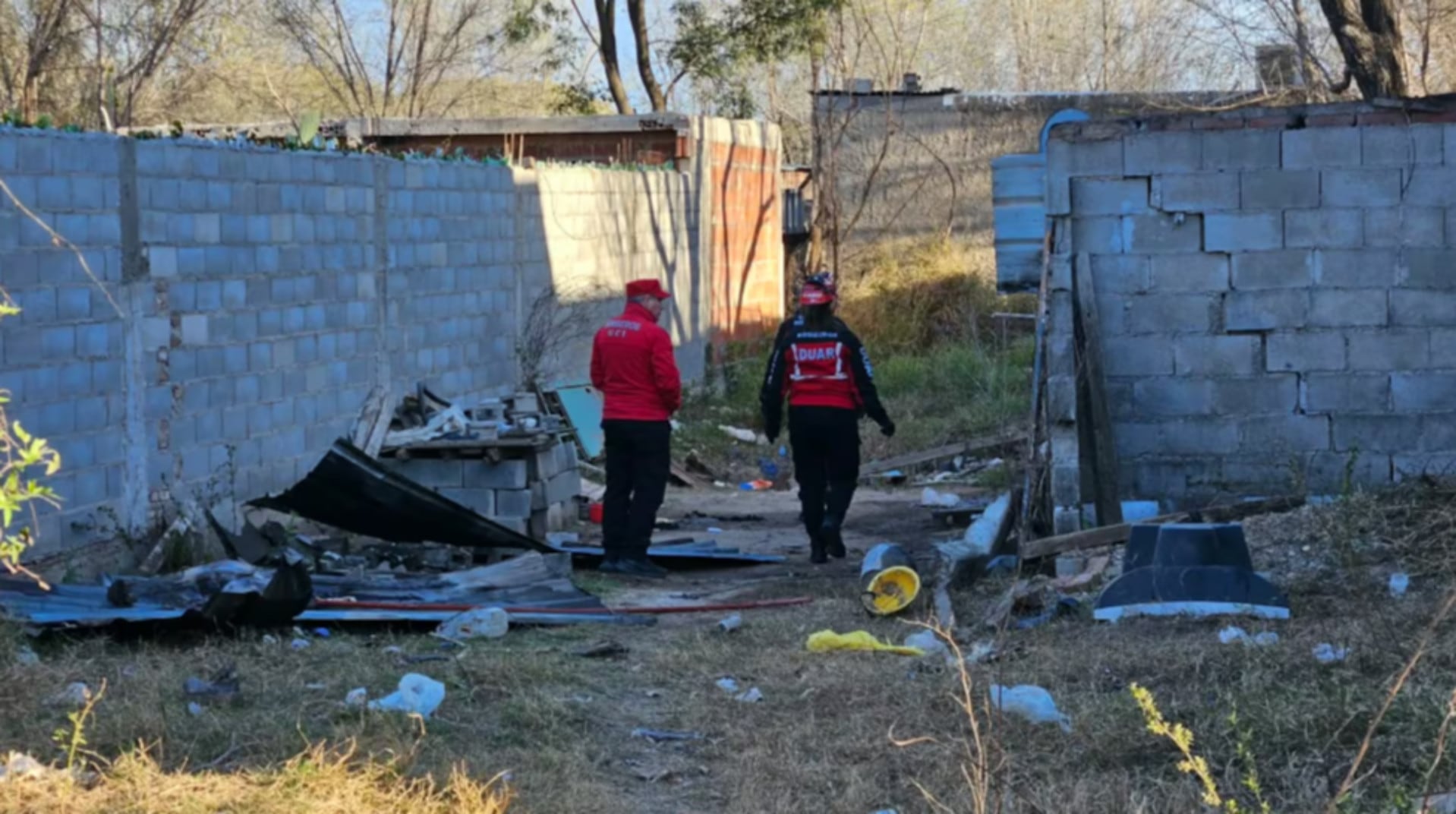 Agentes de seguridad inspeccionan un terreno baldío en Córdoba, sitio de un ataque fatal de un pitbull a un niño de tres años (El Doce.tv)