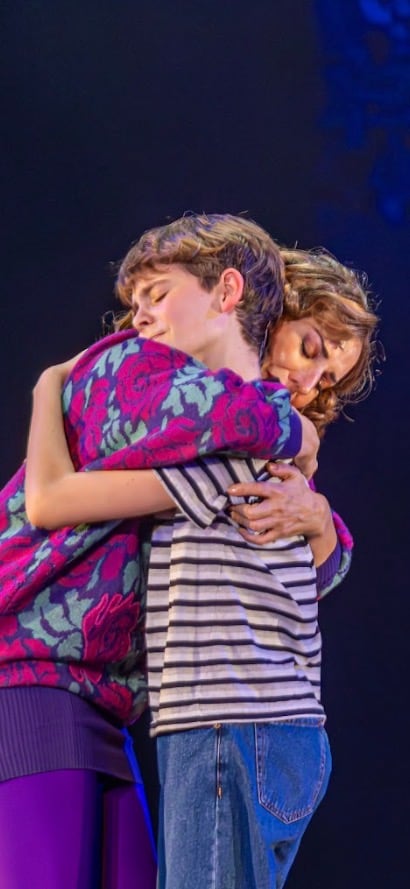 La actriz Alejandra Perlusky, interpretando a Mrs. Wilkinson, abraza al actor que encarna a Billy Elliot durante una escena del musical.