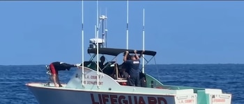 Una embarcación del Departamento de Bomberos del Condado de Los Ángeles navega en el mar con varias personas a bordo