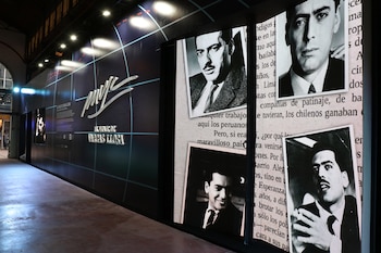 Exhibición de pared oscura con el logo 'MvL' y 'Homenaje de Vargas Llosa', destacando retratos en blanco y negro de un joven escritor junto a textos impresos