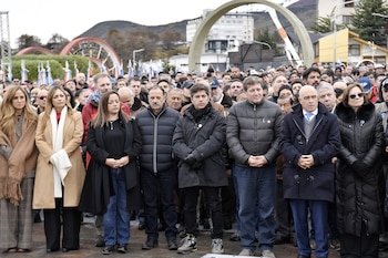 Grupo de personas, incluyendo un veterano de Malvinas con medallas y gorra de la Armada Argentina, y un hombre de chaqueta oscura, parados en un evento al aire libre