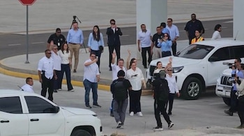 Hernández y sus familiares realizan una oración en la pista del aeropuerto de Palmerola, minutos después de su llegada al país. (fotos: Cortesía)