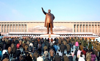 Norcoreanos ante una estatua del
