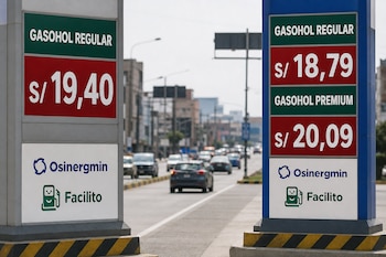 Dos carteles con precios de gasohol regular y premium y logotipos de Osinergmin y Facilito frente a una calle con automóviles.