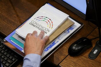 Un integrante de la Convención Constitucional sostiene un cuaderno del organismo durante una sesión en Santiago, Chile