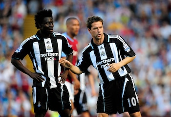 Michael Owen, futbolista del Newcastle United con camiseta de rayas blancas y negras número 10, gesticula mientras un compañero observa en el campo