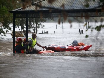 Bomberos circulan con una canoa