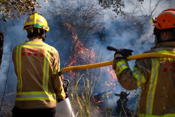 Bomberos trabajan en uno de los focos del incendio en la localidad de Calonge este sábado tras el incendio forestal que comenzó ayer en La Bisbal de l'Empordà