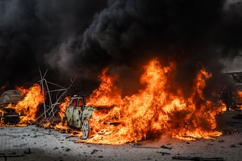 Cars burn in a parking lot after a Russian drone strike on a tractor factory in Dnipro, Ukraine, on Friday, Oct. 23, 2026. (David Guttenfelder/The New York Times)