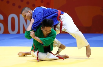 Dos competidores de kurash se enfrentan sobre la alfombra, utilizando técnicas de agarre tradicionales de Uzbekistán-crédito Athit Perawongmetha/REUTERS