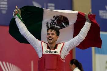 El mexicano Iker Casas celebra tras derrotar al colombiano Miguel Trejos en la final de los -80kg del taekwondo de los Juegos Centroamericanos y del Caribe, el lunes 27 de julio de 2026, en Santo Domingo, República Dominicana. (AP Foto/Fernando Vergara)